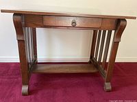 Front view of vintage eastern style solid wood console table showing single drawer and slated leg design.