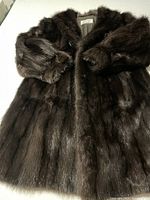 Full view of the dark brown fur coat showing the texture and length