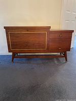 Front view of cedar chest showing brass inlay on front panel, side drawers and angled legs