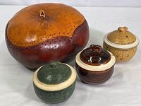 Photo showing the natural gourd warmer and three condiment jars arranged in front of a plain background.