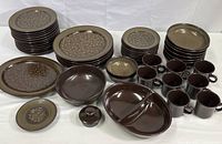 Full view of all Franciscan Madeira dinnerware pieces: plates, bowls, mugs, divided serving bowl, and coffee/teapot top.