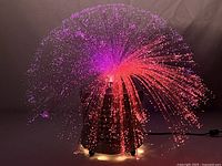 Fiber optic spray lamp lit in purple and red hues showing the fiber optic spray and light effect.