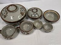 Photo showing all items in the stoneware dinnerware set, detailing size, shape, and floral pattern.