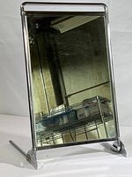 Full front view of the vintage shoe store mirror showing rectangular glass and chrome stand angled backward.