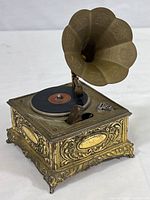 Full view of Swank phonograph style music box lighter showing ornate gold-tone base and flared speaker horn.