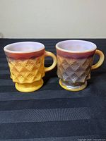 Two vintage Fire King mugs with diamond pattern, front view