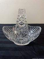 Front view of clear Bohemian crystal basket dish with geometric and pinwheel cut patterns, showing handle and bowl shape.