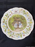 Full view of the collector plate showing central artwork of two mice in front of hedged wooden door, surrounded by floral border, and the title banner 'The Engagement'.