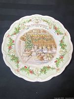 Full view of the collector plate showing central illustration of mice gathering in a festive setting with holly leaf border.