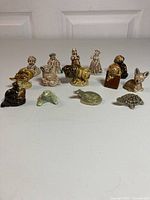 14 Wade England Whimsies figurines arranged showing variety in size and design, mix of human and animal figures