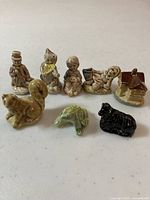 View of all 8 Wade Whimsies figurines arranged on a light surface, showing variety and scale.