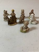 Eight small Wade Whimsies ceramic figurines on a white surface showing various animal and character designs.