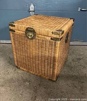 Front and side view of the vintage square wicker and brass rattan storage trunk showing woven wicker body, brass corner reinforcements, and the clasp closure on lid.