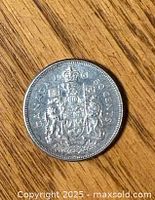 Reverse side of the 1961 Canadian 50 cent coin showing the Canadian coat of arms and denomination.