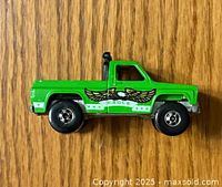 Side view of green Hotwheels pickup truck showing large eagle wing decal and snorkel feature on truck bed side.