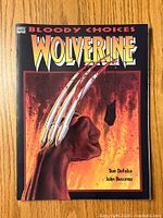 Front cover showing Wolverine's fist with claws extended and fiery background, title 'Bloody Choices Wolverine' by Tom DeFalco and John Buscema.