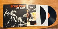 Image of the front album cover titled 'Grand Funk Live Album' with two vinyl records partially removed from sleeves.