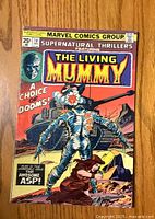 Front cover of Supernatural Thrillers #10 comic book showing The Living Mummy and a tank in the background. Includes the Marvel Comics Group logo and pricing.