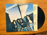 Front cover of The Ramones Leave Home vinyl album with band members standing under a concrete bridge structure.