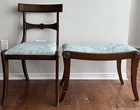 Antique wooden chair and bench viewed from the front, showing upholstery and leg design.