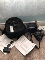 Lot overview including camera bag, battery charger, LP-E12 battery pack, instruction manuals and original box