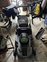 front view of mower showing deck, handle and grass catcher in garage environment