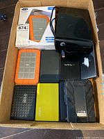 View of all external hard drives in box showing brands and physical condition