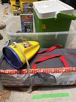 Photo showing the Outbound screen house bag with red handles, yellow water shoes, Coleman cooler, and Silva survival kit in a clear tub.