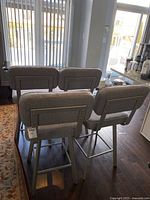 Rear view of all four stools showing backrests and frame alignment