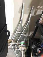 Pair of metal snowshoes leaning against a wall showing overall shape and condition.