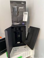 Box opened to reveal Blue Yeti X microphone and user manual inside with foam insert removed to show contents