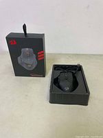 Box and gaming mouse in packaging inserted with cable.