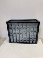 Front view of black plastic storage cabinet with 64 clear plastic drawers arranged 8 rows by 8 columns.
