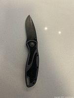 Photo of Kershaw Blur folding knife opened, showing stonewashed blade and grey/black handle.