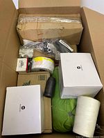 Top view of the box with various items including boxes, rolled fabric, and rolled white item