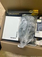 Box with visible OtterBox Symmetry+ phone case, Alleasa cable box, and Infinite Objects packaging, plus other accessories.