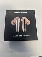 Black product box showing image and branding for Monster N-Lite 203 Airlinks wireless earbuds in rose gold/silver color.
