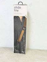 Front of box showing model wearing the Slide Lite camera strap over a grey shirt holding a camera.