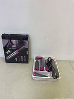 Photo showing hot air styler main unit, 5 attachments in plastic tray, power cord, and original product box.