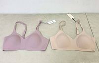 Lot shows two wireless bras side by side, mauve and nude colors, size 34A