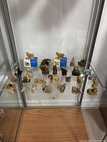 Wide view of entire lot of 26 WADE Whimsies ceramic figurines displayed together including boxed collie and dairy cow, Whoppas Badger, nursery rhyme figures and various animals.