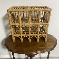 Front view of vintage bamboo wine rack showing arched slots on two levels for 8 wine bottles.