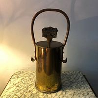 Front view of the vintage brass artillery shell fire starter with handle and attached pumice stone