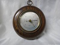 Full front view of the 1950s oak circular barometer showing the wooden frame and dial.