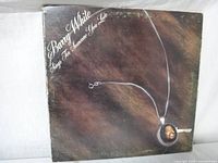 Front cover of Barry White album 'Sings For Someone You Love' showing brown textured background and locket necklace with Barry White photo.