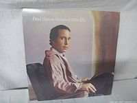 Front of Paul Simon Greatest Hits vinyl record album cover showing Paul Simon seated and looking towards the camera.