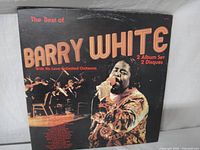 Front cover of the gatefold vinyl album set The Best of Barry White released 1977 showing Barry White singing with orchestra in background.
