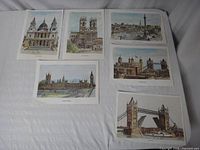Six individual prints showing detailed illustrations of London landmarks laid out flat on a surface.