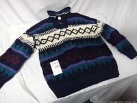 Full view of the alpaca wool sweater laid flat showing front side and knit patterns.