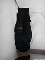 Full view of the black golf travel cover showing the overall shape and padded structure with wheels at the bottom.